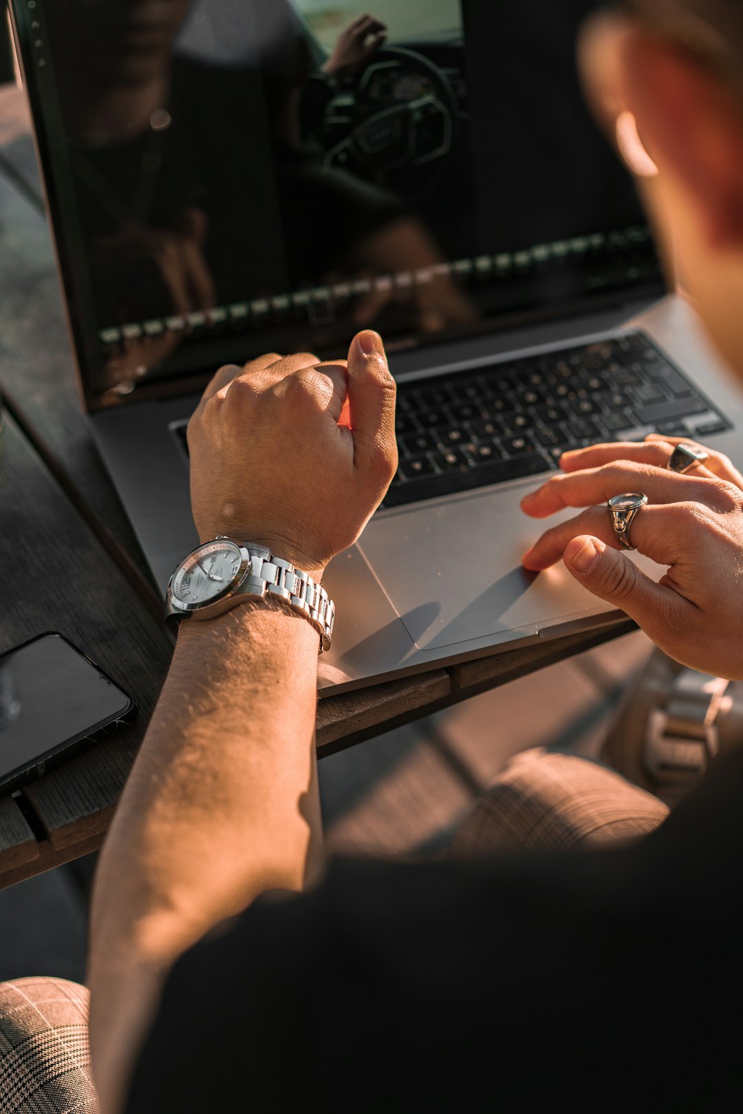 Close up of hands typing on a laptop displaying financial charts