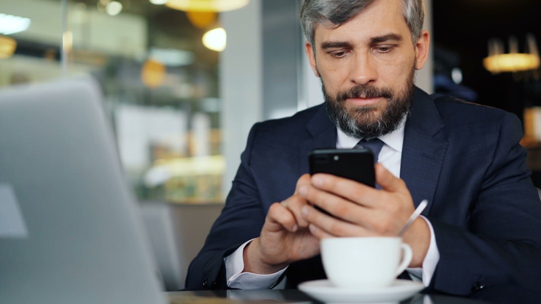 Portrait of a confident senior businessman in a suit looking at his phone